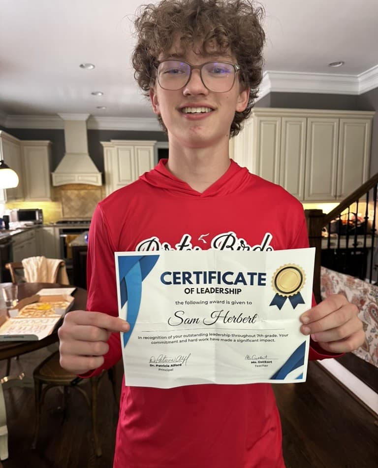 Sam Herbert holding his Certificate of Leadership.