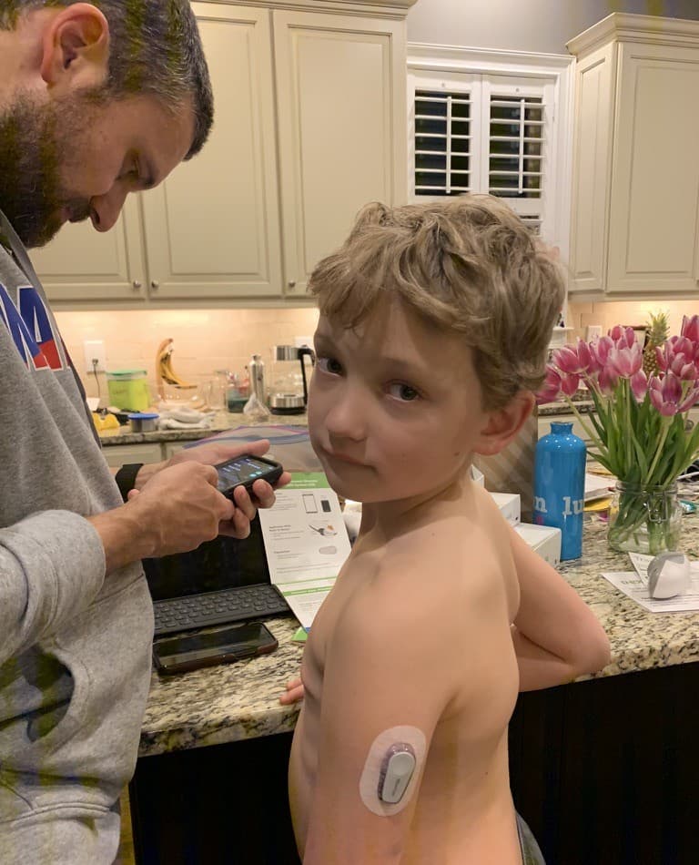 Chris and Sam in the kitchen, checking his CGM sensor.